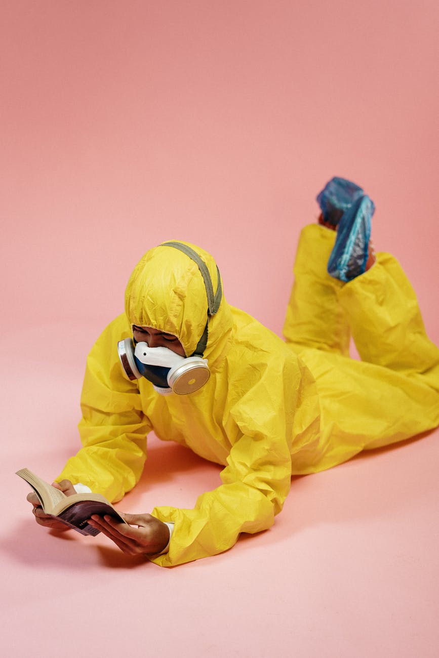 person in yellow coveralls reading a book